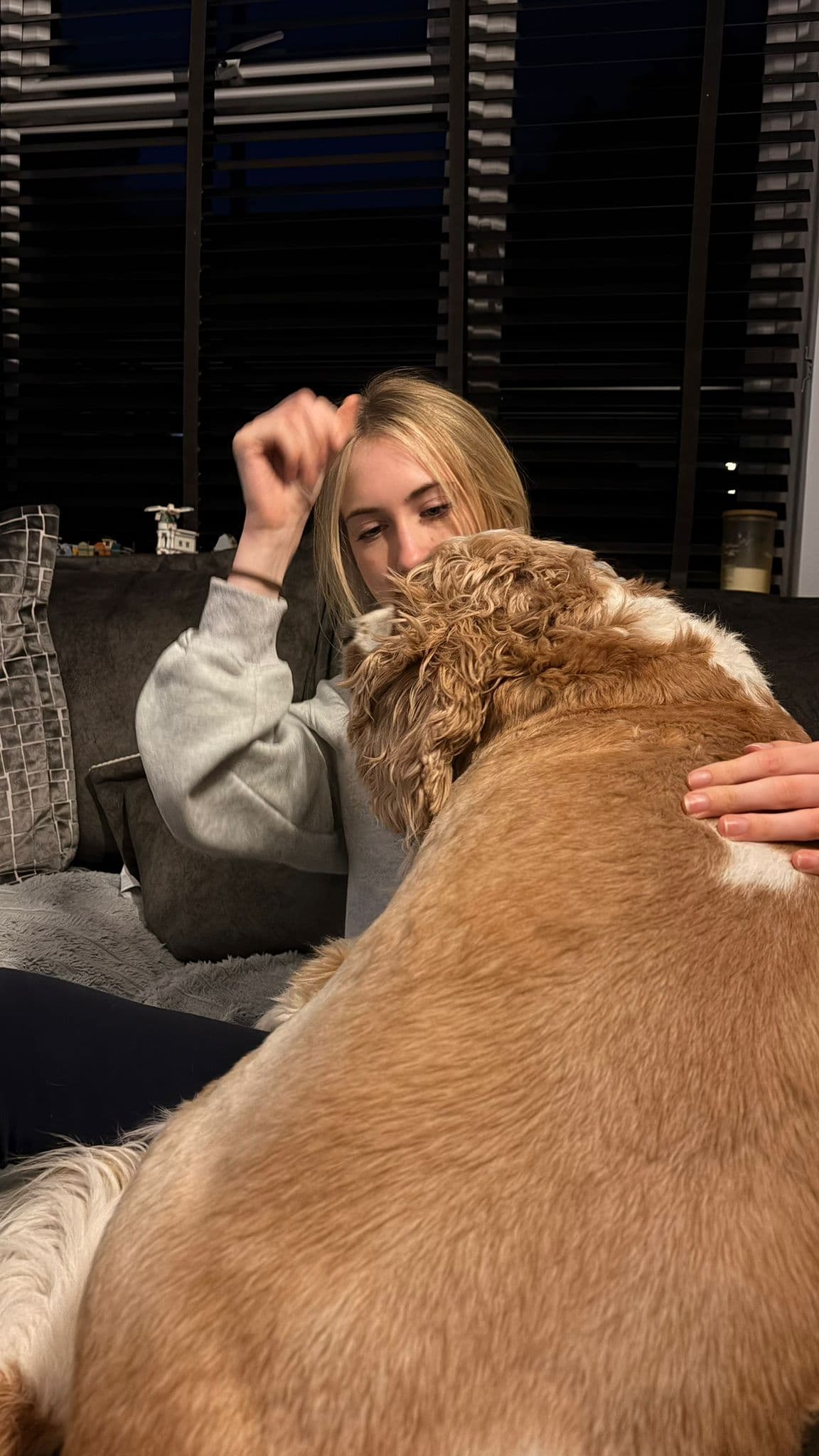 Belle cuddling a dog at home